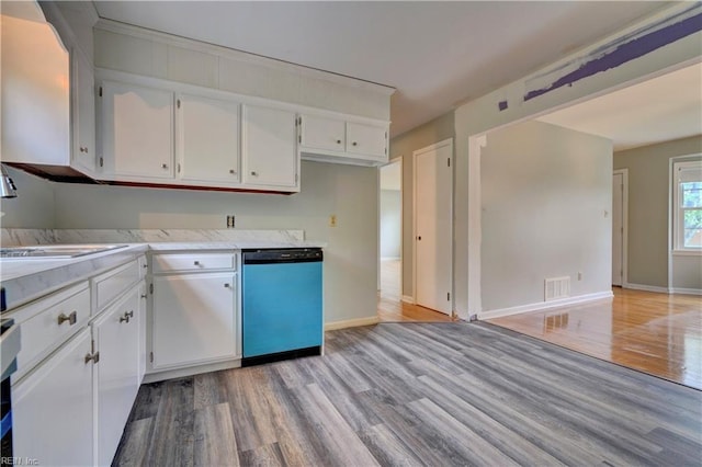 kitchen with visible vents, light wood finished floors, white cabinetry, and dishwashing machine