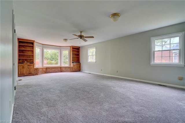 carpeted spare room with ceiling fan, baseboards, and visible vents