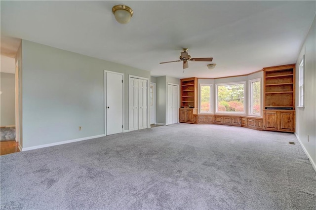 unfurnished living room with baseboards, a ceiling fan, and carpet floors