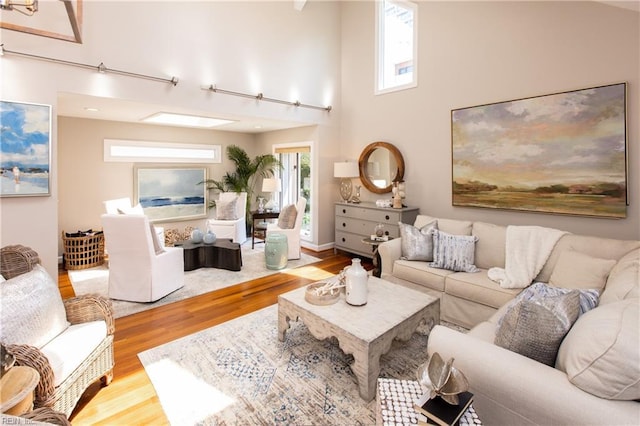living area with a high ceiling and wood finished floors