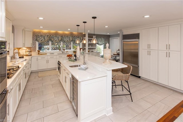 kitchen with a sink, an island with sink, recessed lighting, and stainless steel appliances