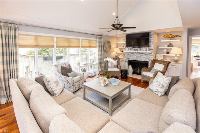 living area featuring a wealth of natural light, vaulted ceiling, a ceiling fan, and wood finished floors
