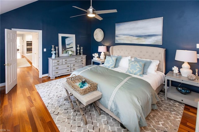 bedroom with wood finished floors, baseboards, a ceiling fan, and vaulted ceiling