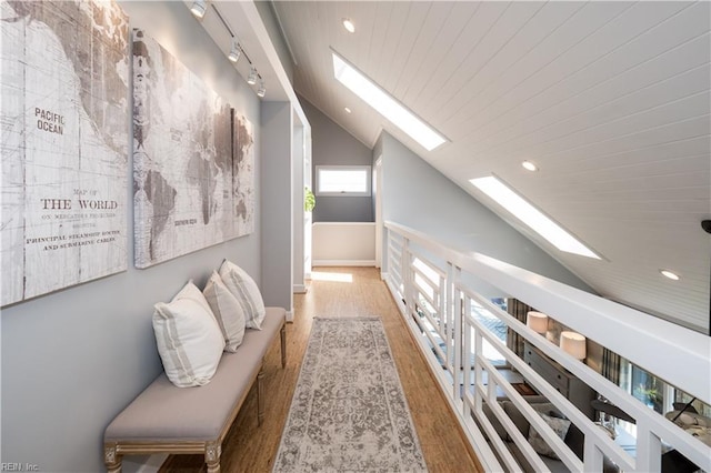 hallway with recessed lighting, lofted ceiling with skylight, and wood finished floors
