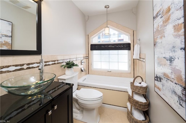 bathroom with vanity, tile patterned floors, toilet, tile walls, and a garden tub