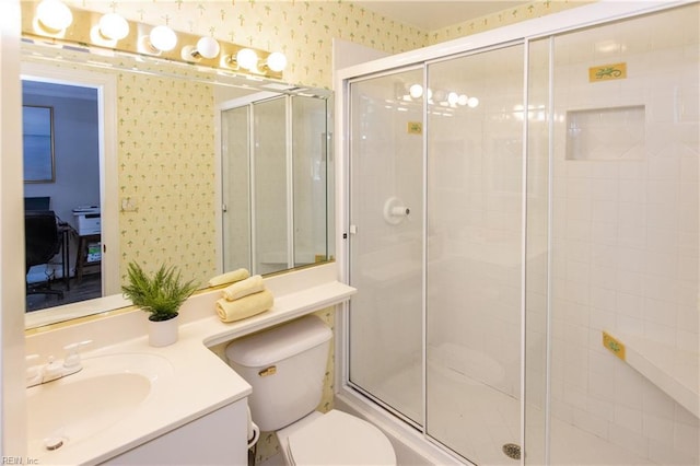full bathroom with a shower stall, vanity, wallpapered walls, and toilet