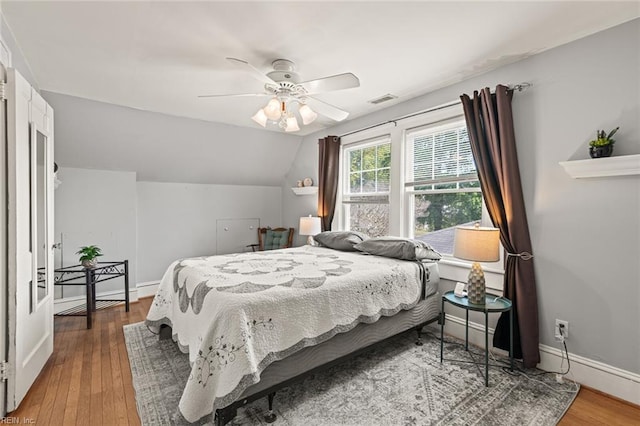 bedroom with wood finished floors, baseboards, and visible vents