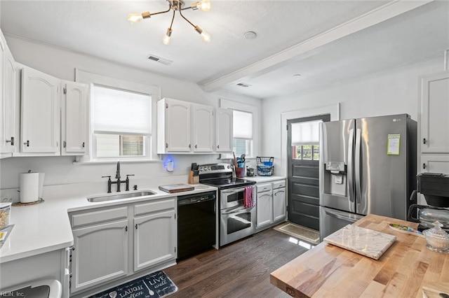 kitchen with visible vents, a sink, dark wood-style flooring, light countertops, and stainless steel appliances