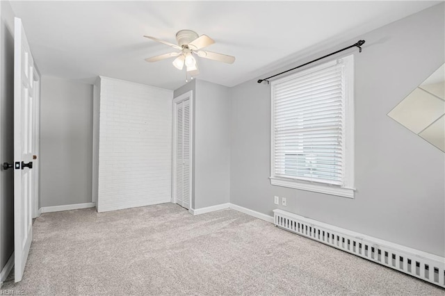 unfurnished bedroom featuring a closet, baseboards, a ceiling fan, carpet, and baseboard heating