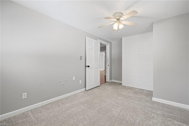 spare room with ceiling fan, carpet, and baseboards