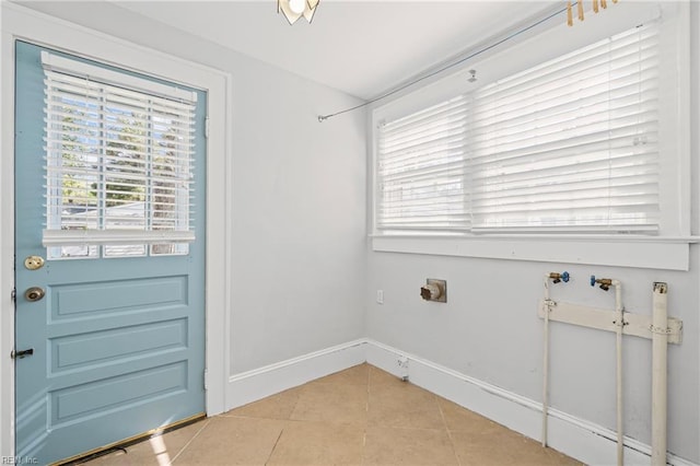 interior space with hookup for a washing machine, plenty of natural light, light tile patterned flooring, and laundry area