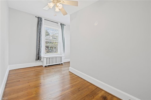 unfurnished room with baseboards, ceiling fan, and wood finished floors