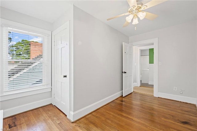 unfurnished bedroom featuring light wood-style flooring, ceiling fan, and baseboards