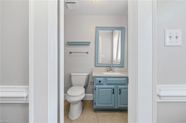 bathroom featuring visible vents, baseboards, toilet, vanity, and tile patterned floors