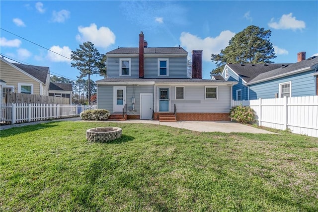 rear view of property featuring entry steps, a fenced backyard, a patio, and a chimney