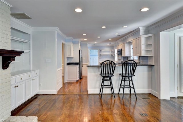 kitchen featuring visible vents, open shelves, a peninsula, and stainless steel appliances