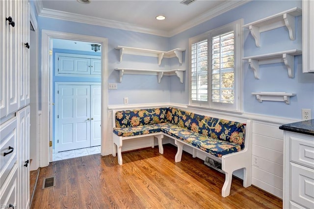 sitting room with visible vents, ornamental molding, recessed lighting, wainscoting, and wood finished floors