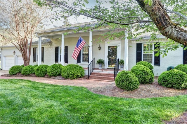 view of front of house featuring a garage, a front yard, and brick siding
