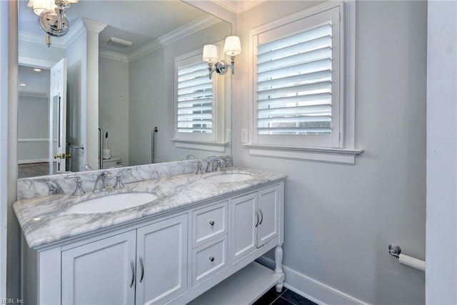bathroom with a sink, ornamental molding, baseboards, and double vanity
