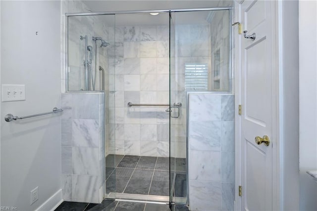bathroom featuring a shower stall and baseboards