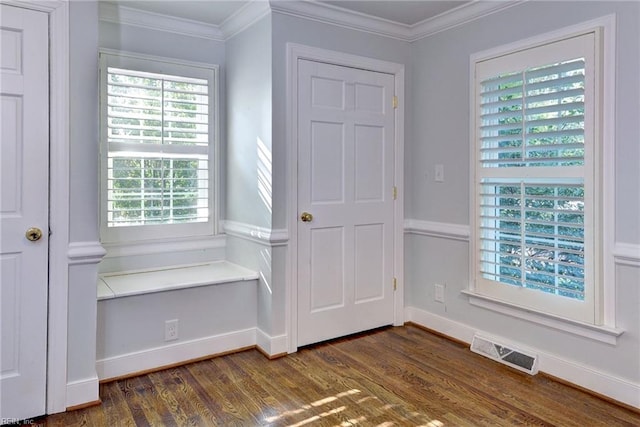 mudroom with dark wood-style flooring, ornamental molding, visible vents, and plenty of natural light