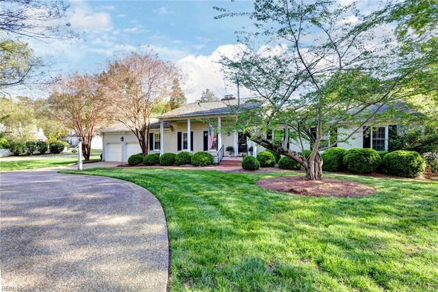 view of front facade featuring a garage, driveway, stucco siding, and a front lawn