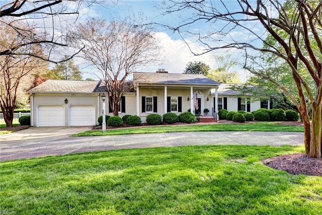 view of front of property with a front yard, a chimney, an attached garage, and aphalt driveway