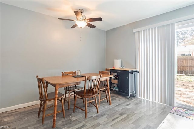 dining area with light wood-type flooring, ceiling fan, and baseboards