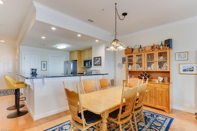 dining area featuring light wood finished floors, recessed lighting, and ornamental molding