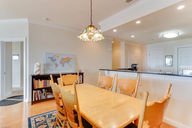 dining area with recessed lighting, ornamental molding, and light wood-style flooring