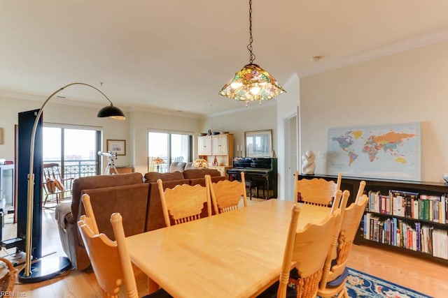 dining area featuring wood finished floors and ornamental molding