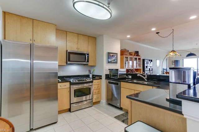 kitchen featuring dark countertops, a sink, light tile patterned flooring, light brown cabinetry, and appliances with stainless steel finishes