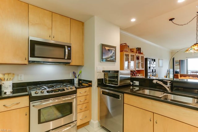 kitchen featuring ornamental molding, dark countertops, a sink, stainless steel appliances, and light brown cabinets