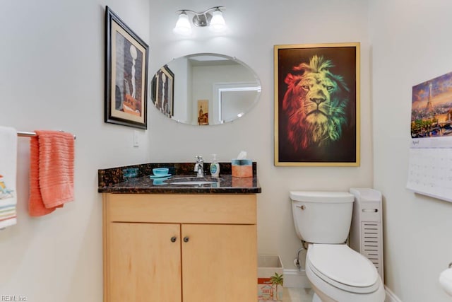 half bathroom featuring baseboards, vanity, and toilet