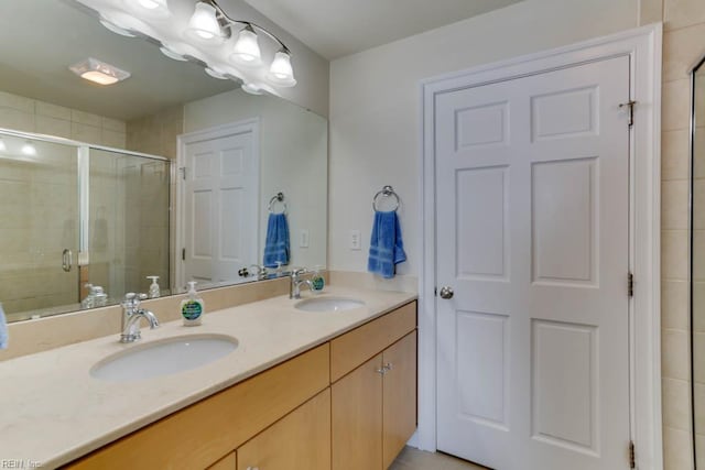 bathroom featuring a sink, a shower stall, and double vanity