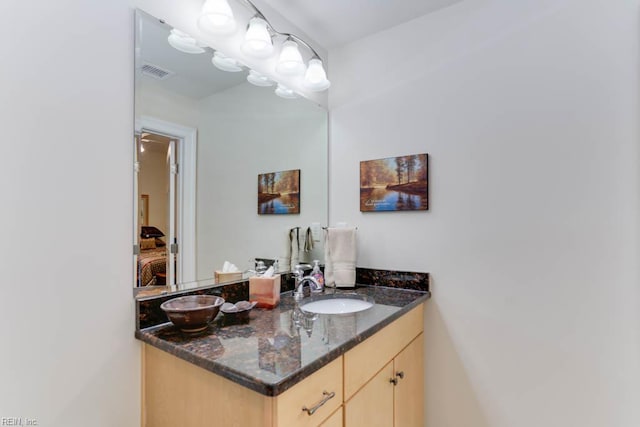 bathroom featuring connected bathroom, vanity, and visible vents