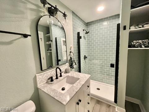 bathroom featuring a shower stall, vanity, toilet, and wood finished floors