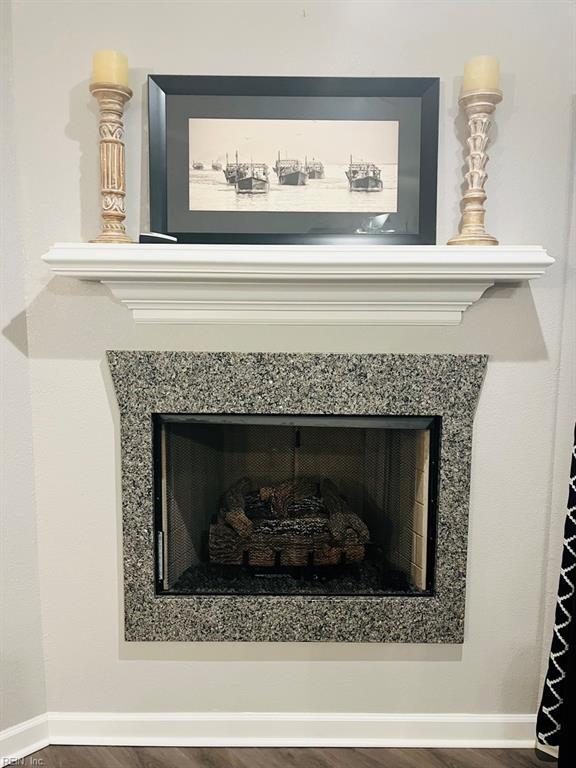 interior details with a fireplace, baseboards, and wood finished floors