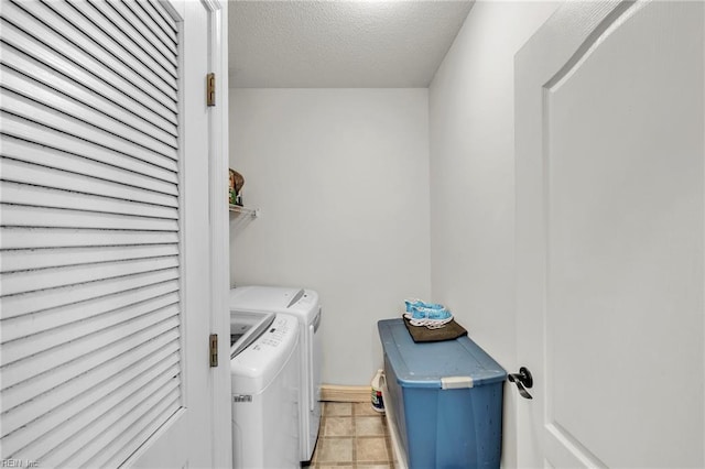 laundry area with laundry area, washing machine and clothes dryer, and a textured ceiling