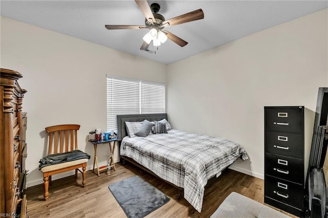 bedroom featuring baseboards, a ceiling fan, and wood finished floors