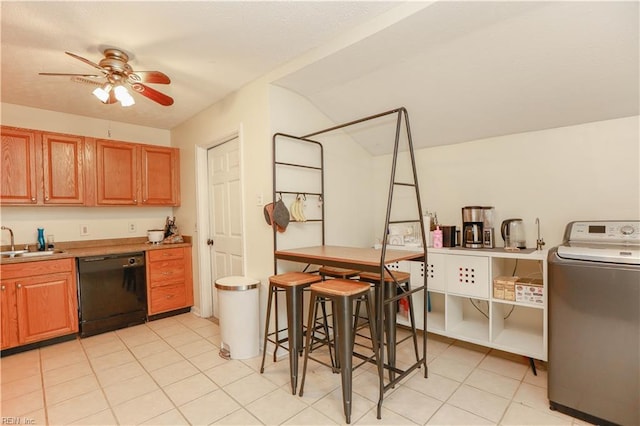 kitchen with washer / clothes dryer, light tile patterned floors, black dishwasher, a sink, and a ceiling fan