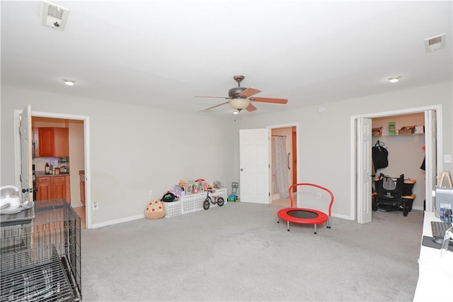 recreation room with carpet, visible vents, baseboards, and a ceiling fan