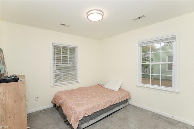 bedroom with baseboards, visible vents, and carpet floors