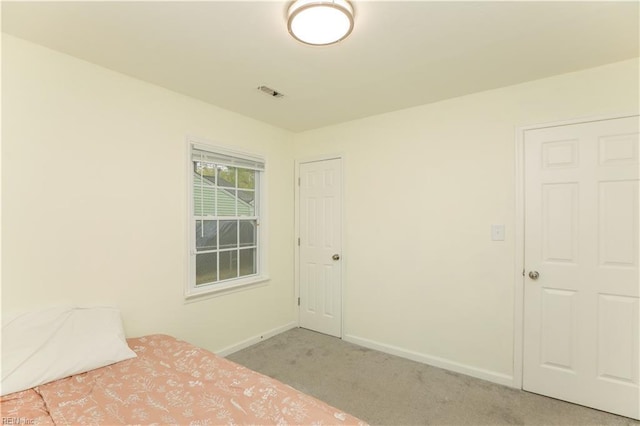 unfurnished bedroom featuring light carpet, baseboards, and visible vents