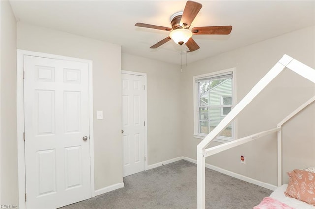 unfurnished bedroom with baseboards, ceiling fan, and carpet