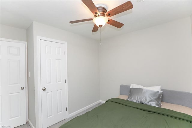 bedroom featuring light carpet, baseboards, and ceiling fan