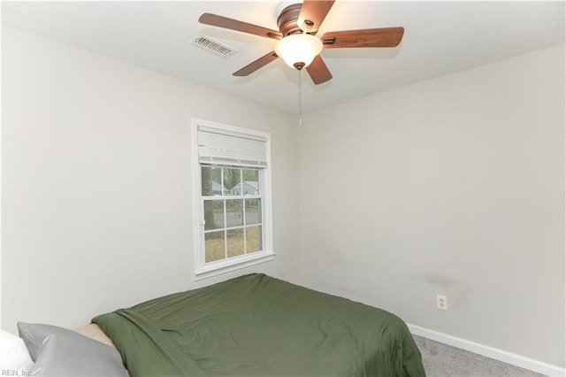 carpeted bedroom with visible vents, baseboards, and a ceiling fan