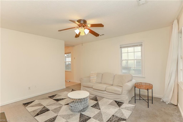 living room featuring baseboards and a ceiling fan