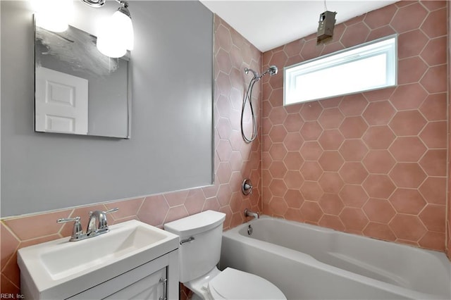 full bath with toilet, tile walls, vanity, and bathing tub / shower combination