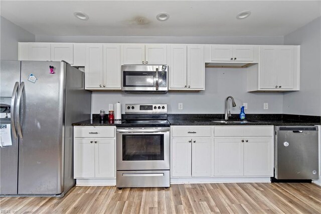 3410 E Princess Anne Rd, Norfolk, VA 23502 - kitchen with light wood-style flooring, a sink, white cabinets, and stainless steel appliances